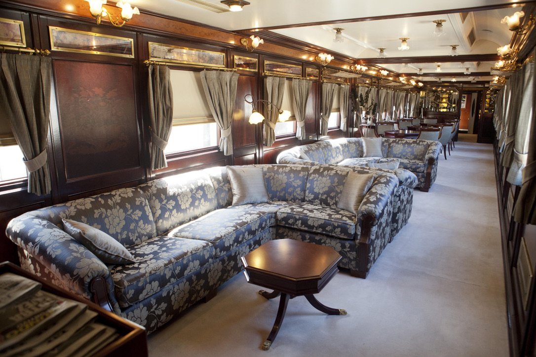 The elegant Belle Epoque salon car aboard the Al Ándalus luxury train, with polished wood panelling and period furnishings.