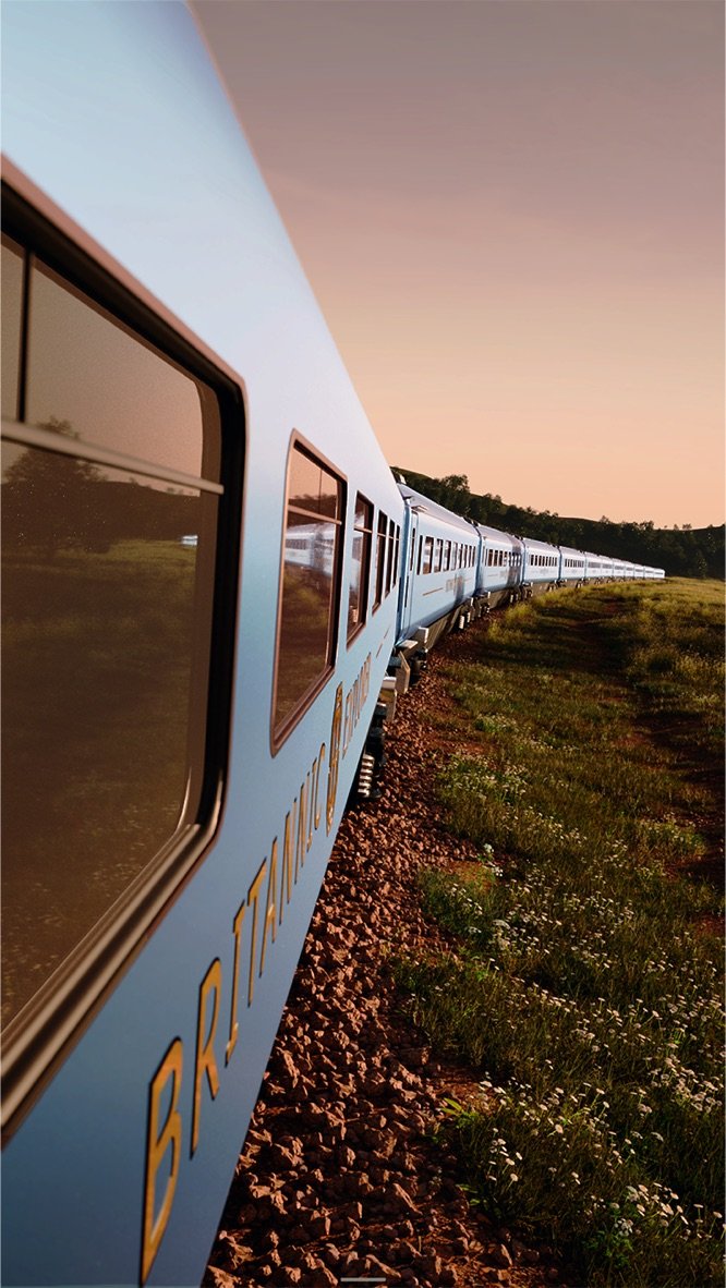 The Britannic Explorer luxury sleeper train travelling through the green countryside of England on a UK rail holiday.