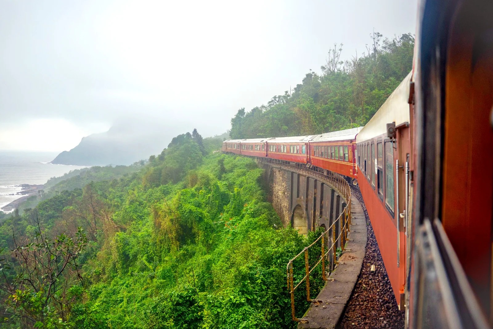SJourney luxury train curving along a coastal viaduct in Vietnam